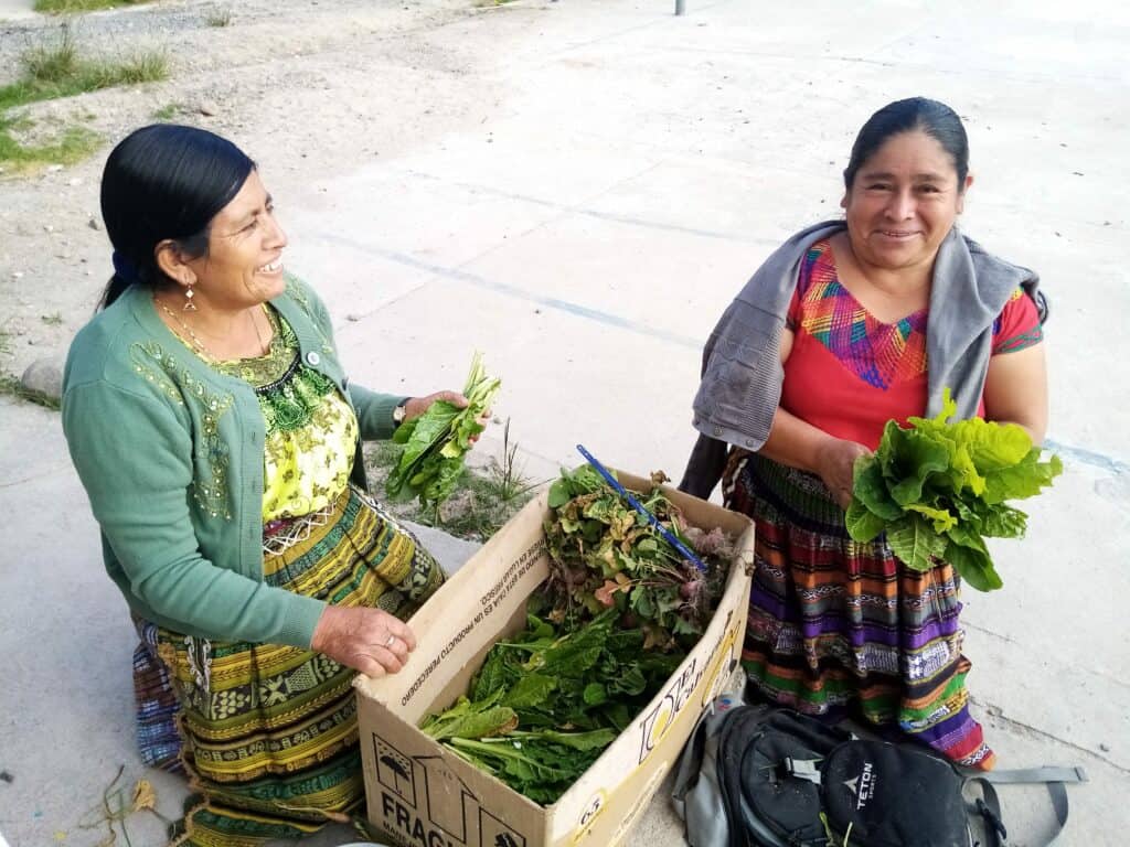 Two women holding fresh garden produce
